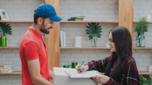 Cliente assinando o recebimento da mudança com o entregador